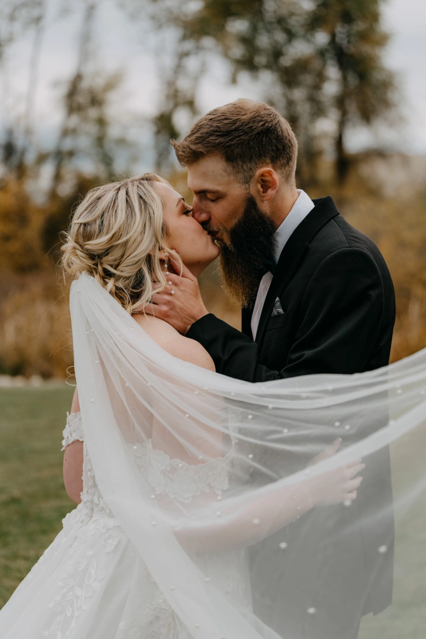Newlyweds kissing beneath the bride's flowing veil